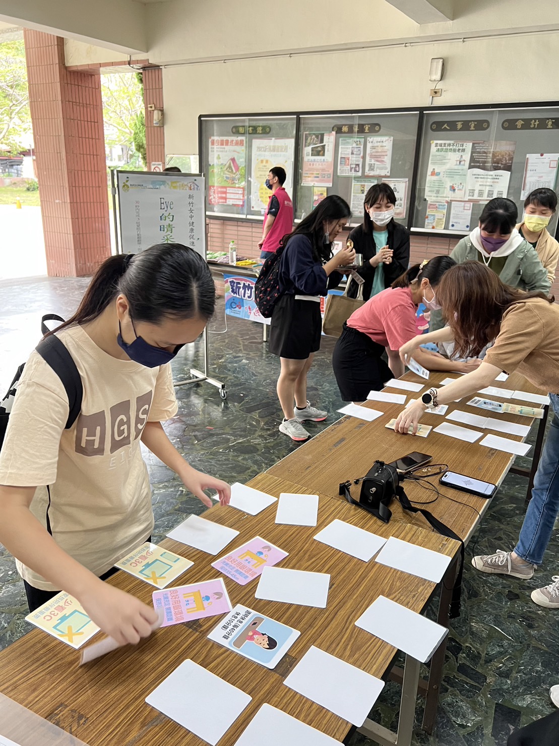 學生圍繞活動桌，參與健康促進卡片配對遊戲。