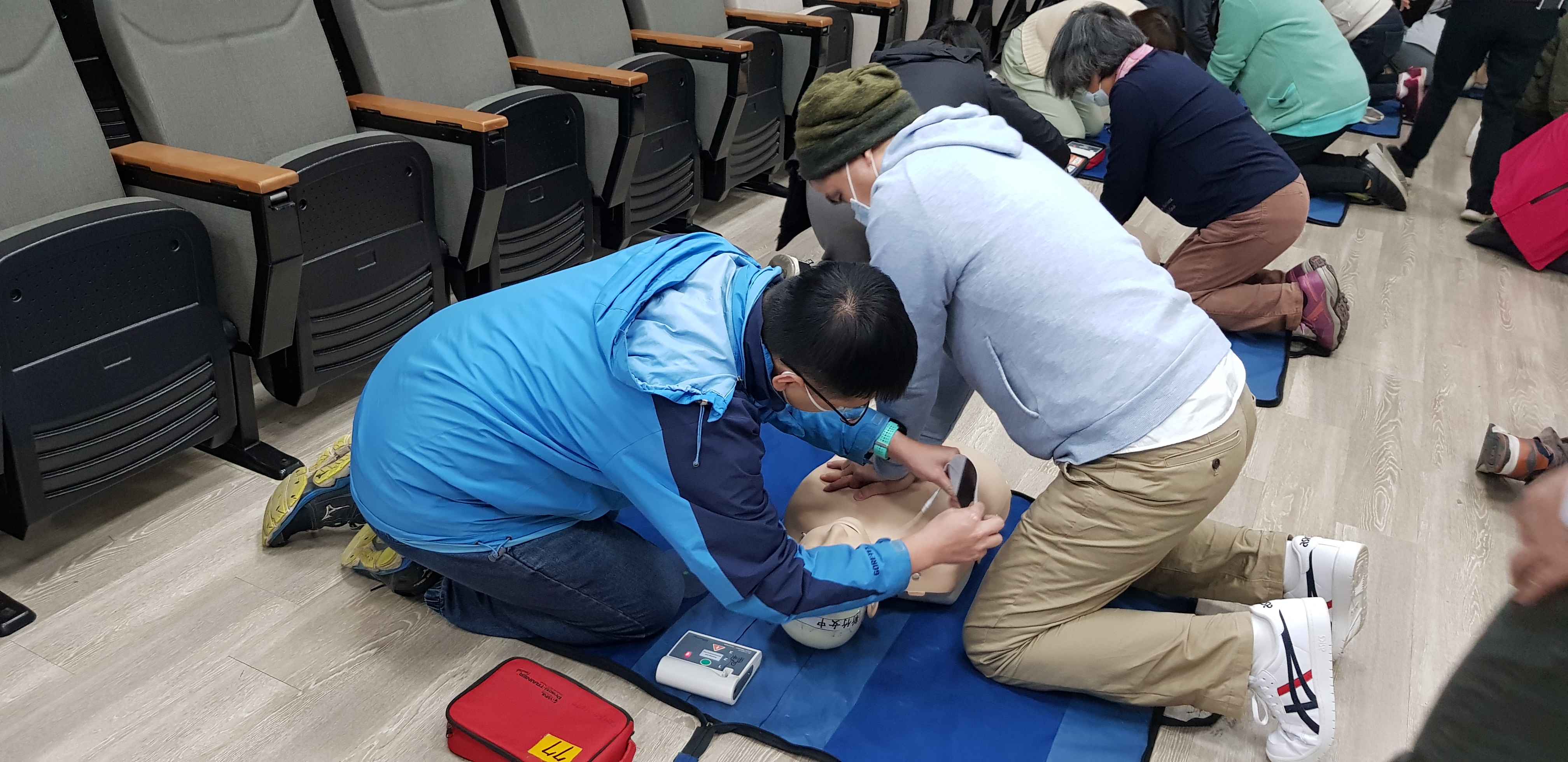 教職員工專注在安妮模型上操作 AED 自動體外心臟電擊去顫器。