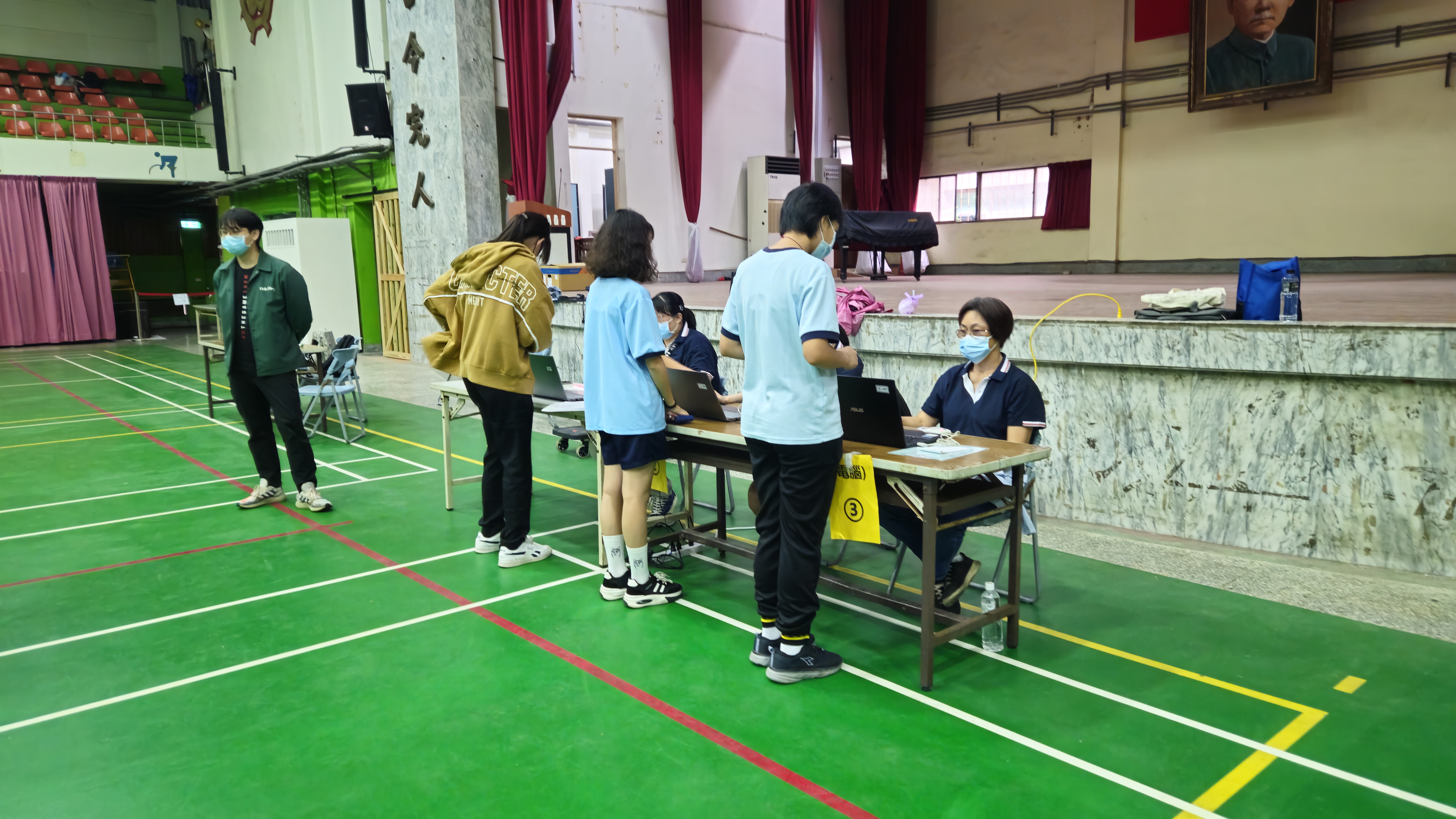 學生們在育樂中心內的報到櫃檯前進行評估。