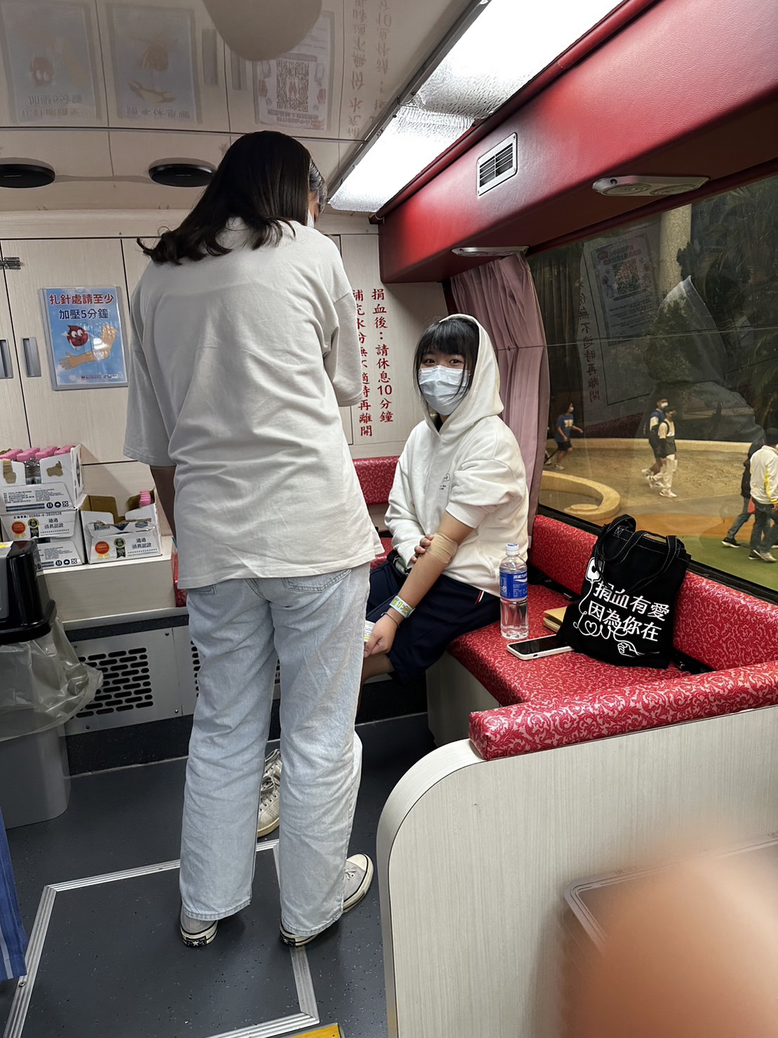 醫護人員於捐血車內部關心捐血後學生狀況。